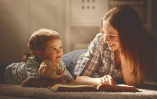 mum reading a story to young daughther