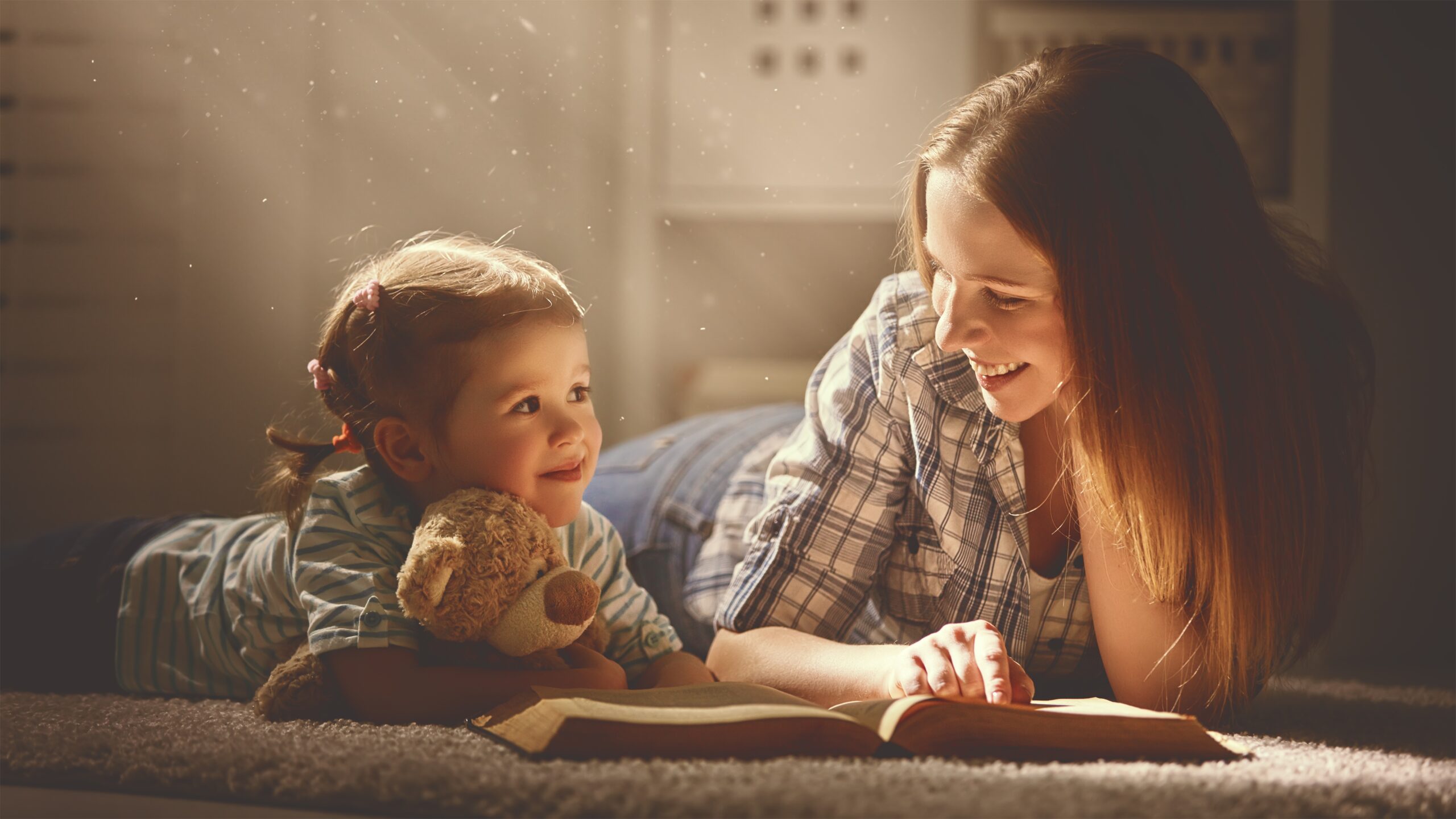 mum reading a story to young daughther