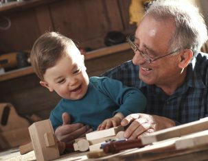 grandad helping grandson with woodwork