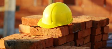builders yellow helmet on a pile of bricks