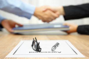 businessmen shaking hands with agreement on the table