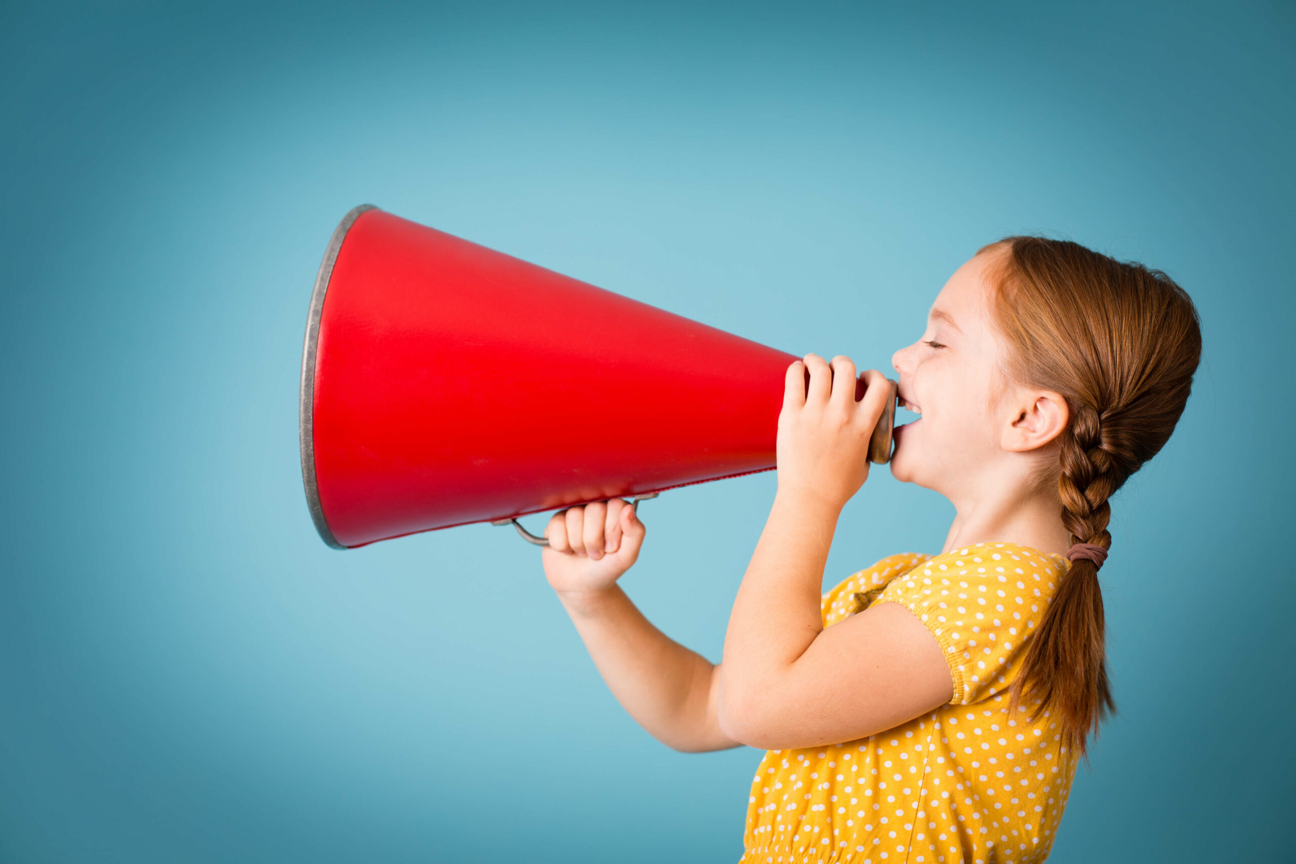 girl talking through a red horn