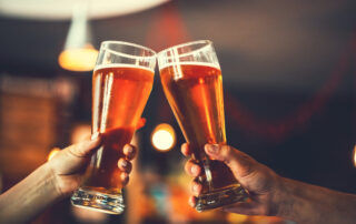 two friends cheering with two pints