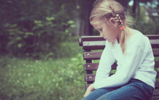 sad girl sitting on a bench