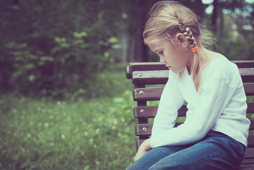 sad girl sitting on a bench