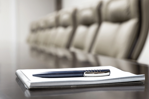 boardroom table with pen and paper