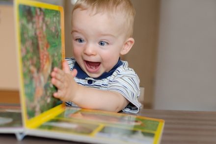 happy boy turning a book