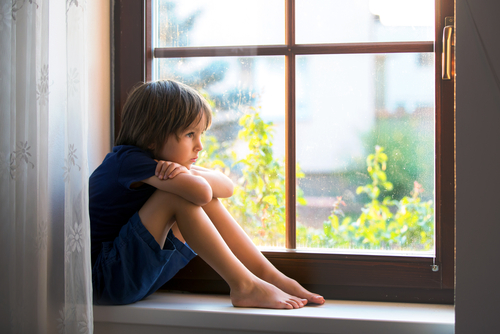 sad boy looking out of the window