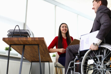 manager interviewing a man in a wheelchair for a job role