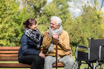 Carer looking after an elderly person in the park