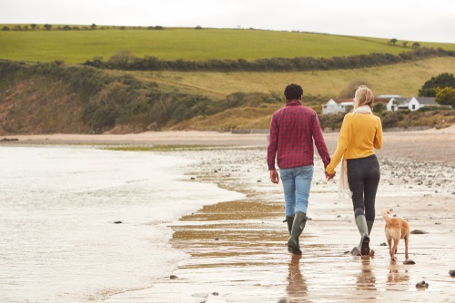 a man and woman holding hands on a beach